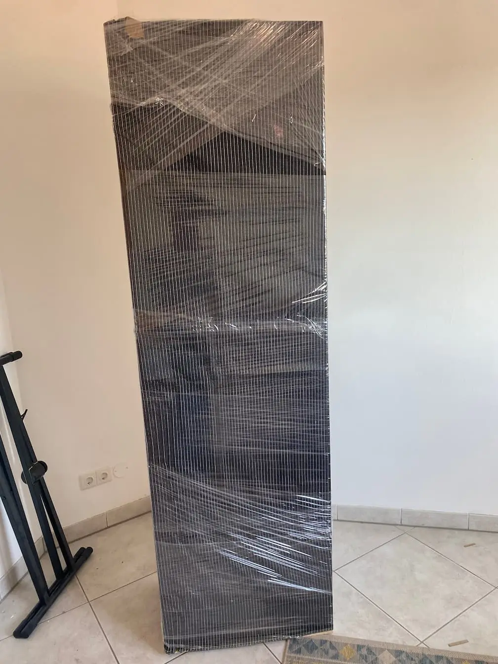 Eine große flache Platte, in Decke und Folie gewickelt, an die Wand gelehnt