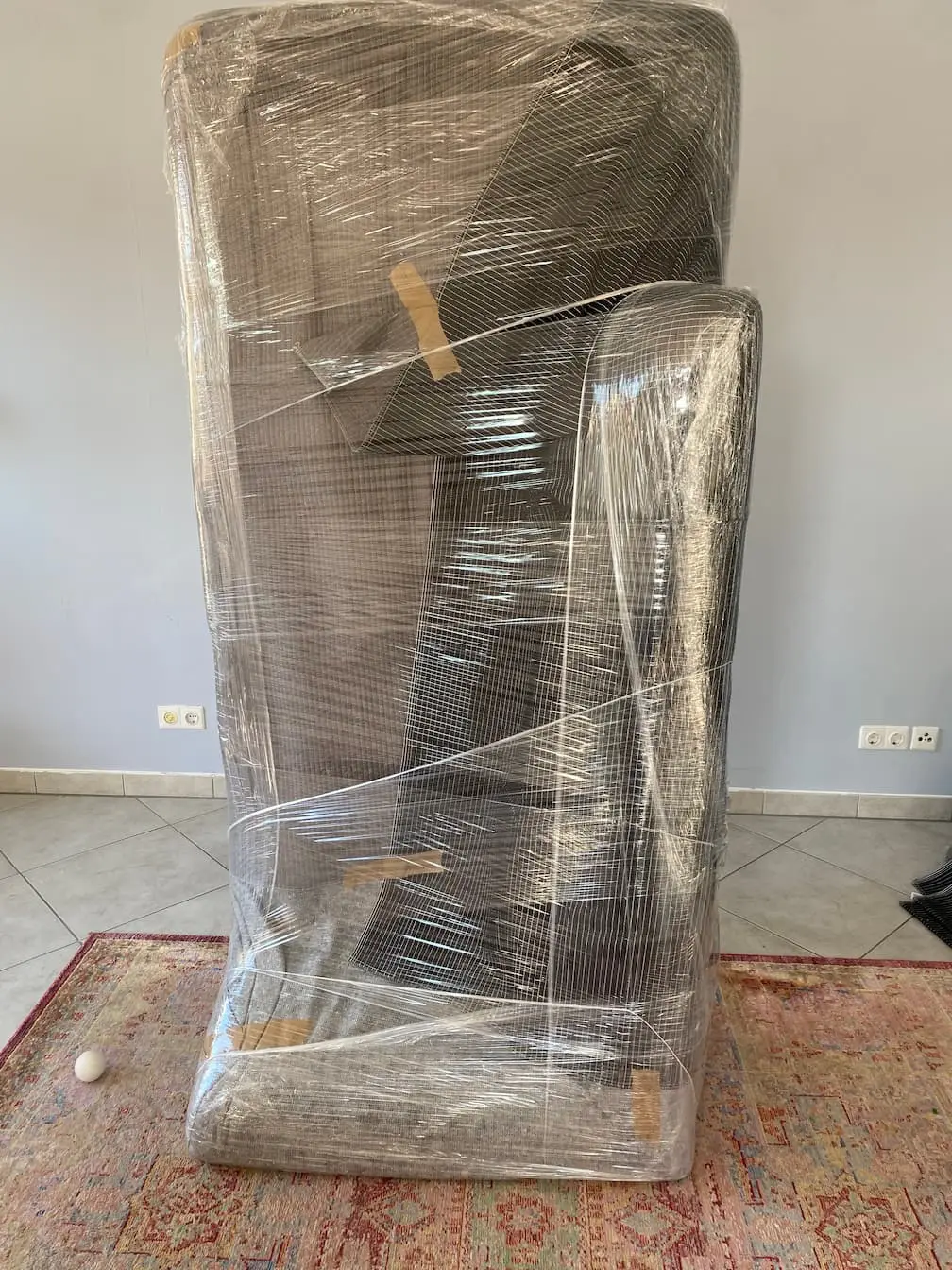 Ein gewickelter Schrank steht verpackt in einem geräumten Zimmer